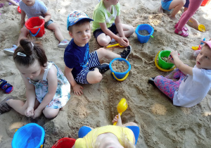 Dzieci bawia się w piaskownicy w ogrodzie przedszkolnym